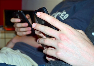 Die Hände von Jugendlichen am Smartphone.