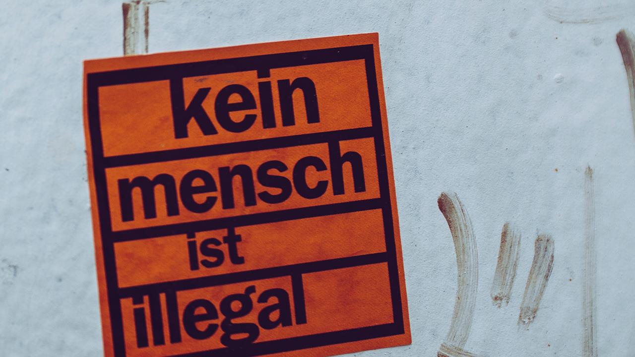 Sticker an Hauswand mit Aufschrift "Kein Mensch ist illegal"