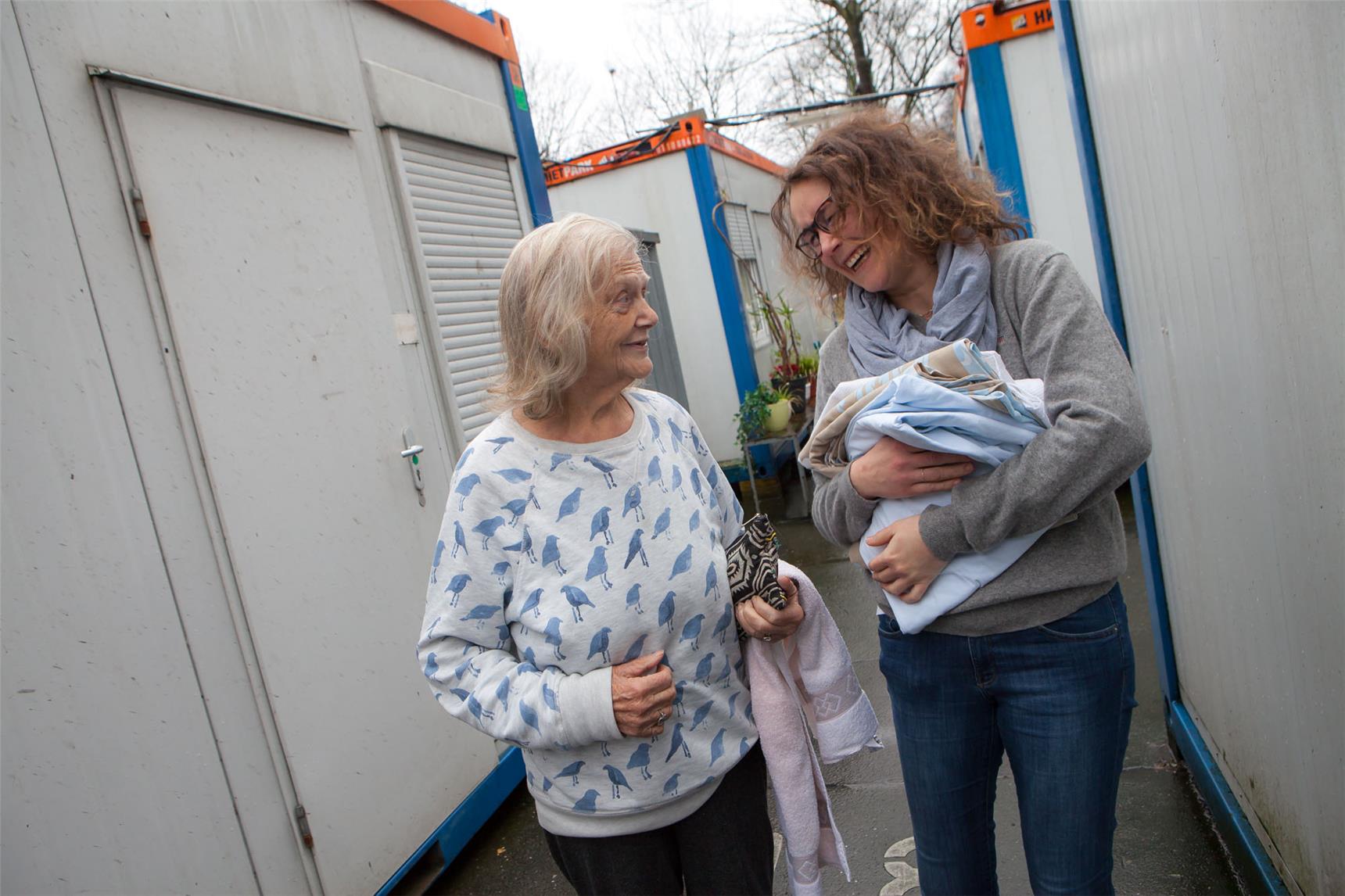Eine wohnungslose Frau spricht mit einer Sozialarbeiterin vom Container-Projekt in Hamburg.