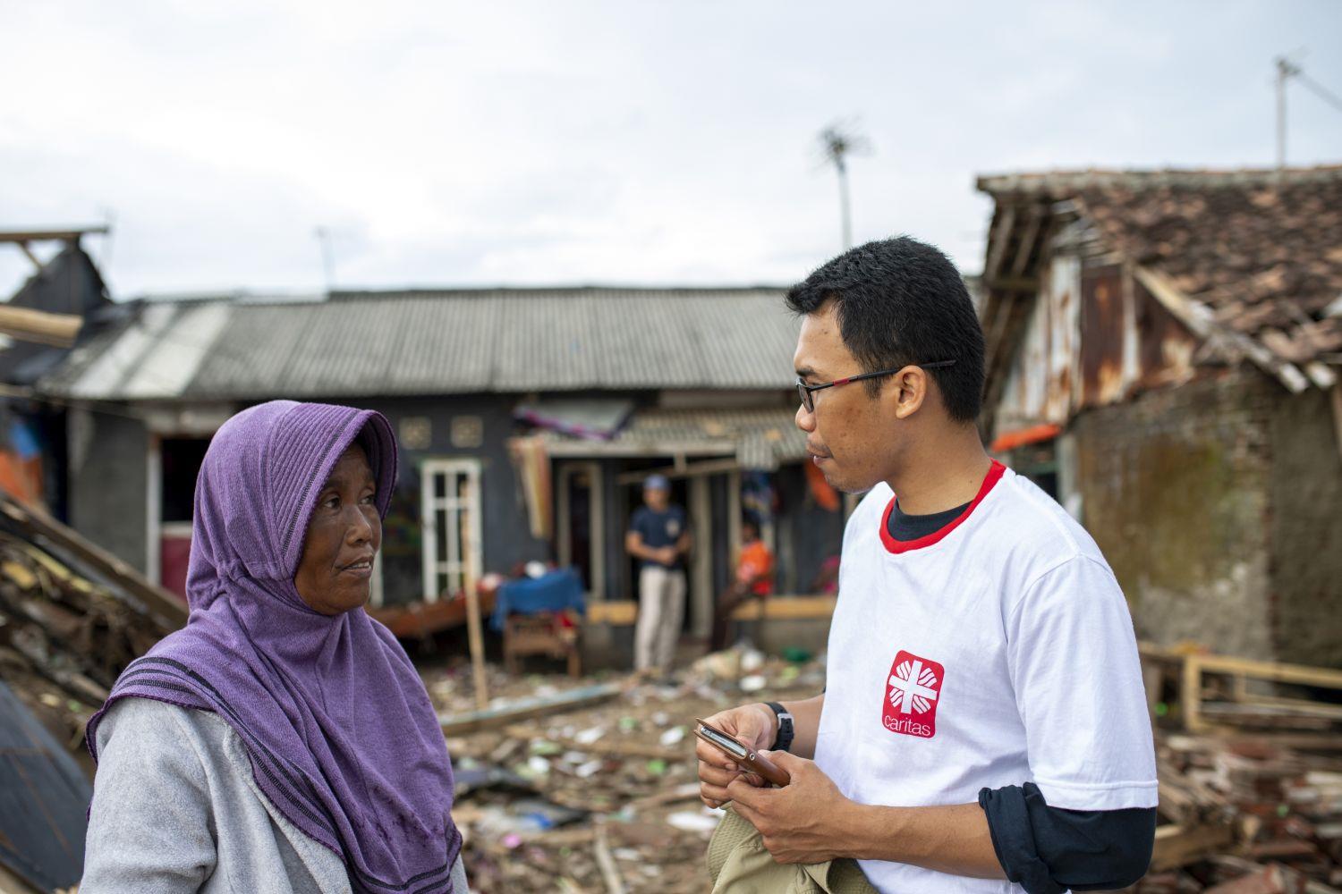 Caritas-Mitarbeiter aus Indonesien im Gespräch mit einer älteren Frau