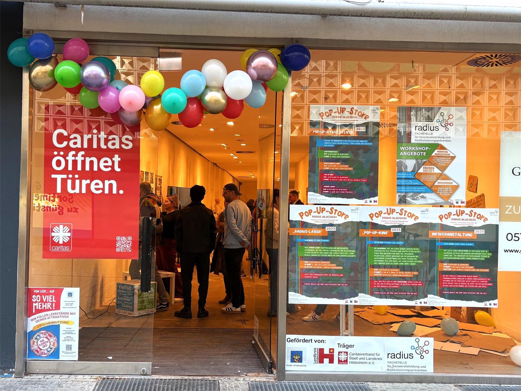 Der Eingang in der Innenstadt ist mit einer Girlande an Lusftballons geschmückt und lädt zum eintreten ein.