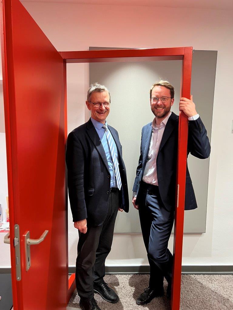Frank Johannes Hensel, DiCV Direktor in Köln, und Friedrich von Schönfeld, DCV-Vorstand Finanzen und Recht, stehen in einem roten Kampagnentürrahmen. 