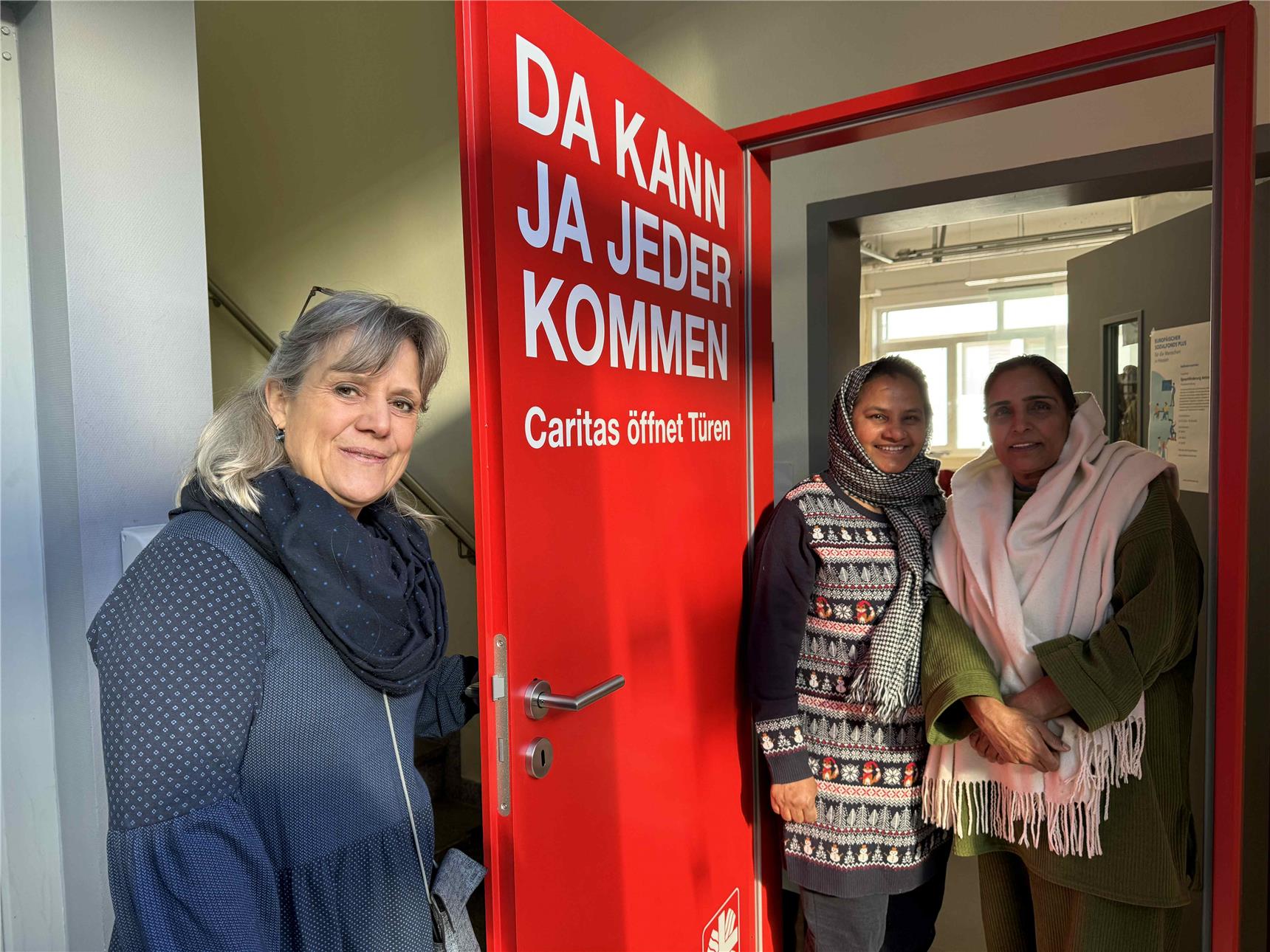 Die rote Tür wird direkt als Fotospot von drei Frauen genutzt.