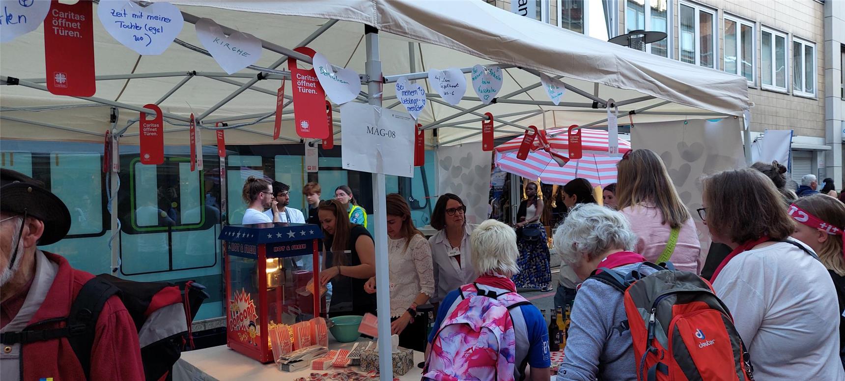Die Türanhänger der Caritas-Kampagne schmücken als selbstgebastelte Girlande den Caritas-Stand auf dem Evangelischen Kirchentag in Hannover.