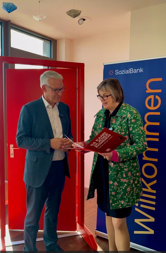 ie Caritas-Präsidentin Eva Welskop-Deffaa besucht Prof. Dr. Harald Schmitz mit der Roten Kampagnentür in Köln.