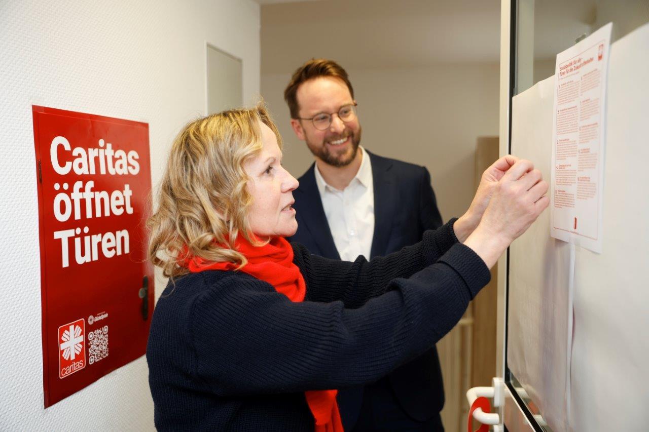 Steffi LemkeSteffi Lemke, Spitzenkandidatin der Grünen in Sachsen-Anhalt mit Friedrich von Schönfeld, Caritas-Vorstand Recht und Finanzen, stehen vor den 10 Thesen zum Sozialstaat. An der Wand hinter ihnen ein Kampagnenplakat 