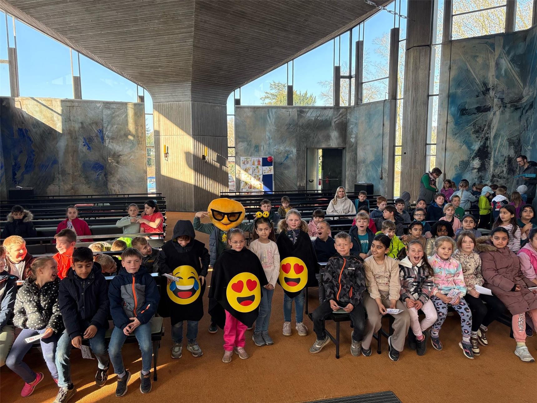 Eine Gruppe Kinder hat sichlich Spaß und haben große Smiley dabei.