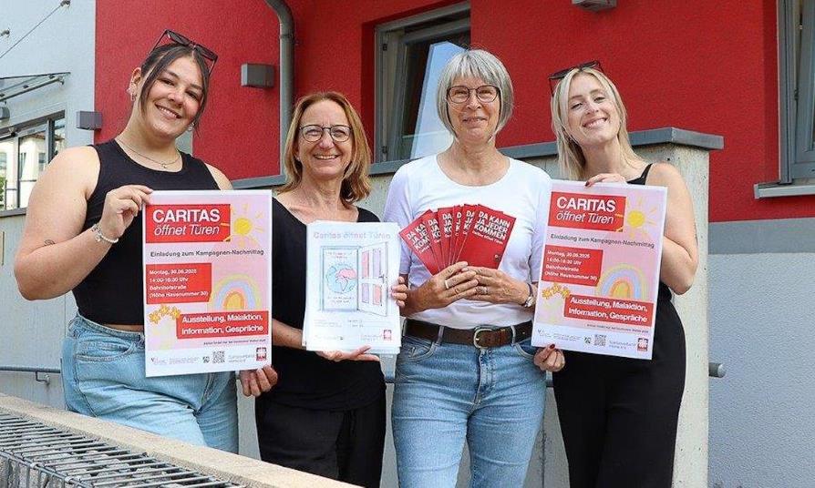 Vier Frauen vor einem roten Gebäude mit Material zur Kampagne 