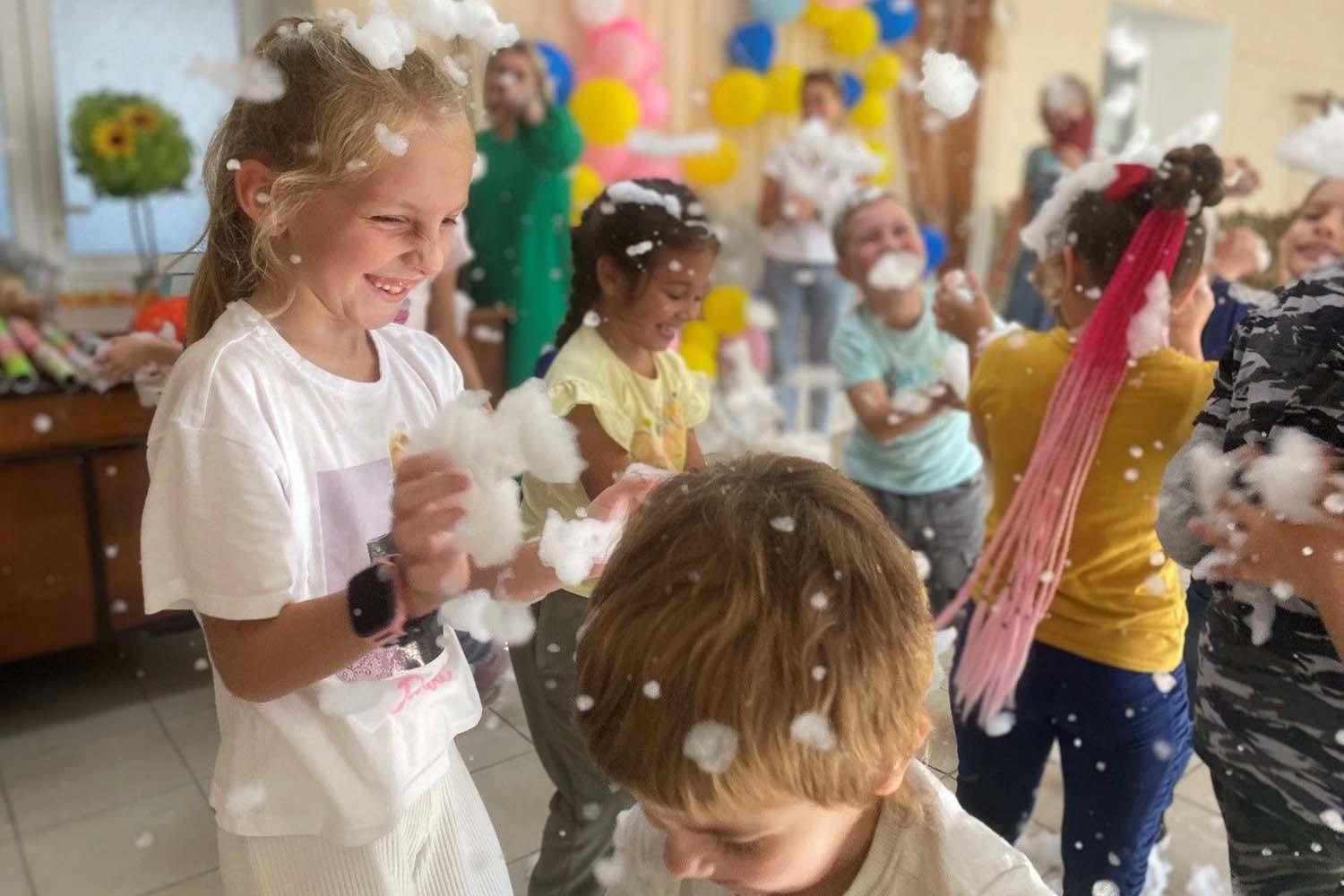 Kinder in einem bunten Raum spielen und lachen.