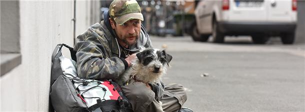 Mann mit Hund bettelt in Innenstadt