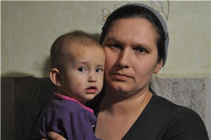 Ukrainische Mutter mit Tochter auf dem Arm