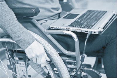 Laptop auf dem Schoß eines Rollstuhlfahrers