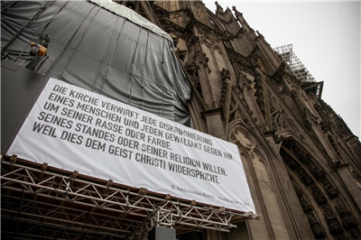 Banner mit kirchlichem Zitat auf dem Kölner Dom
