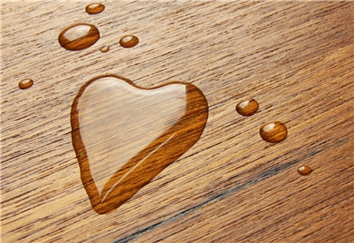 Hier wurde ein Herz mit Wasser auf eine Tischplatte gemalt.