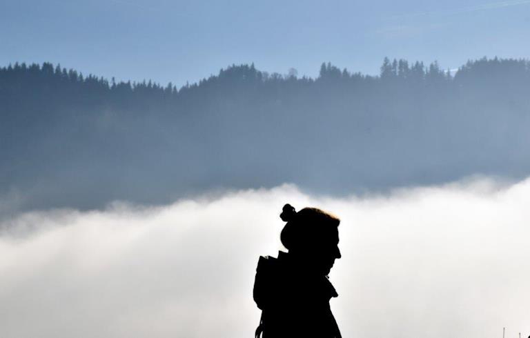 Junge Frau allein im Nebel.