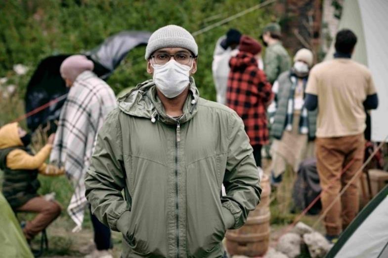 Junger Migrant mit Mundschutz.