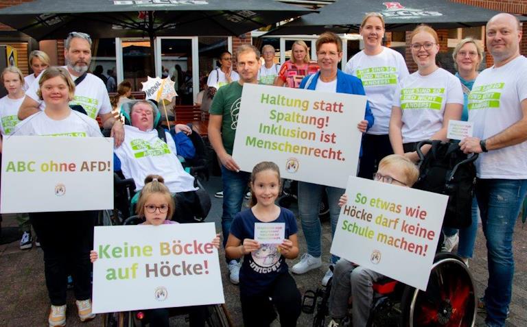 Eine Gruppe von Menschen mit und ohne Behinderung hält Demo-Schilder gegen den AfD-Funktionär Bernd Höcke.