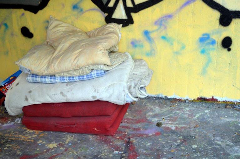 Aufgestapeltes Bettzeug eines Obdachlosen im Freien.