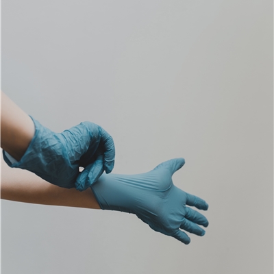 H�nde mit blauen Handschuhen f�r Pflege und Medizin