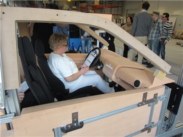 Eine Pflegekraft beurteilt ihre Sitzposition im Fräsmodell des E-Autos.