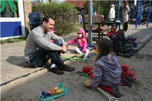 Erzieher Paco spielt mit Kindern im Sandkasten