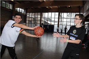 Ehrenamtlicher und Flüchtling beim Basketball