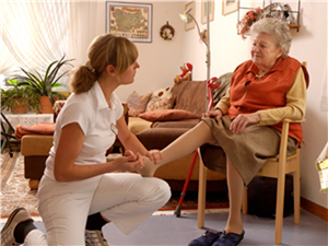 Pflegerin behandelt Fuß alter Frau