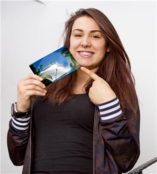 Junge Frau mit Foto eines Kreuzfahrtschiffes
