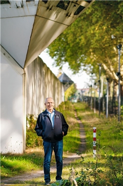 Walter Fassbender, der ehrenamtliche Knast-Besuche macht, vor der Gefängnismauer - über ihm ein Wachturm.
