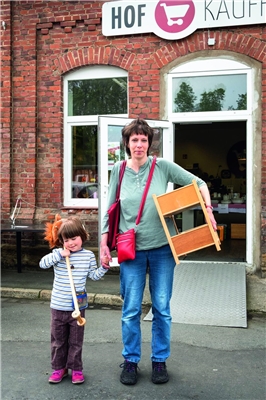 Eine Mutter mit ihrem Kind haben in den Goslarschen Höfen ein Kleinmöbel und ein Steckenpferd gekauft.