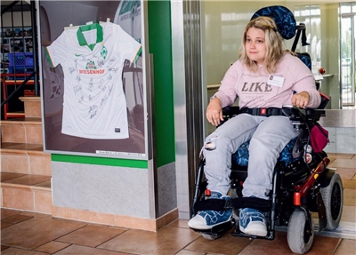 Saskia Busjahn verlässt mit ihrem Rollstuhl einen Aufzug.