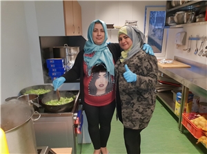 Auf dem Bild sind zwei Frauen in einer Suppenküche zu sehen