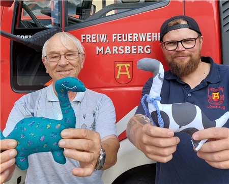 In Marsberg im Einsatz: Hans-Dieter Weller, Teilnehmer Caritas-Tagesstruktur, und Feuerwehrmann Matthias Wegener zeigen die „Muttiere“, die Kinder bei Notfällen trösten sollen. 