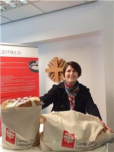 Leiterin Beate Czodrowski vom Caritas-Zentrum Ludwigshafen mit zwei Stofftaschen voller gefüllter Tüten. 