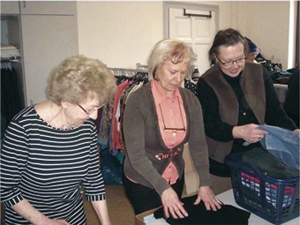 Frauen beim Sortieren von Kleidung in der Kleiderkammer