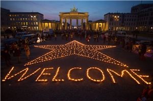 Aus vielen Teelichtern ist ein großer Stern entstanden, der vor dem Brandenburger Tor in Berlin leuchtet. Zusätzlich der Schriftzug 