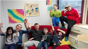 Haus für Kinder 1 Kinder sitzen auf einem Sofa und winken