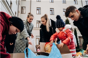 In der Ukraine holen Frauen und Kinder Lebensmittelpackungen aus Kartons
