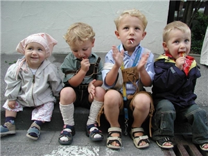 Gruppe von kleinen Kindern sitzt auf einem Bordstein
