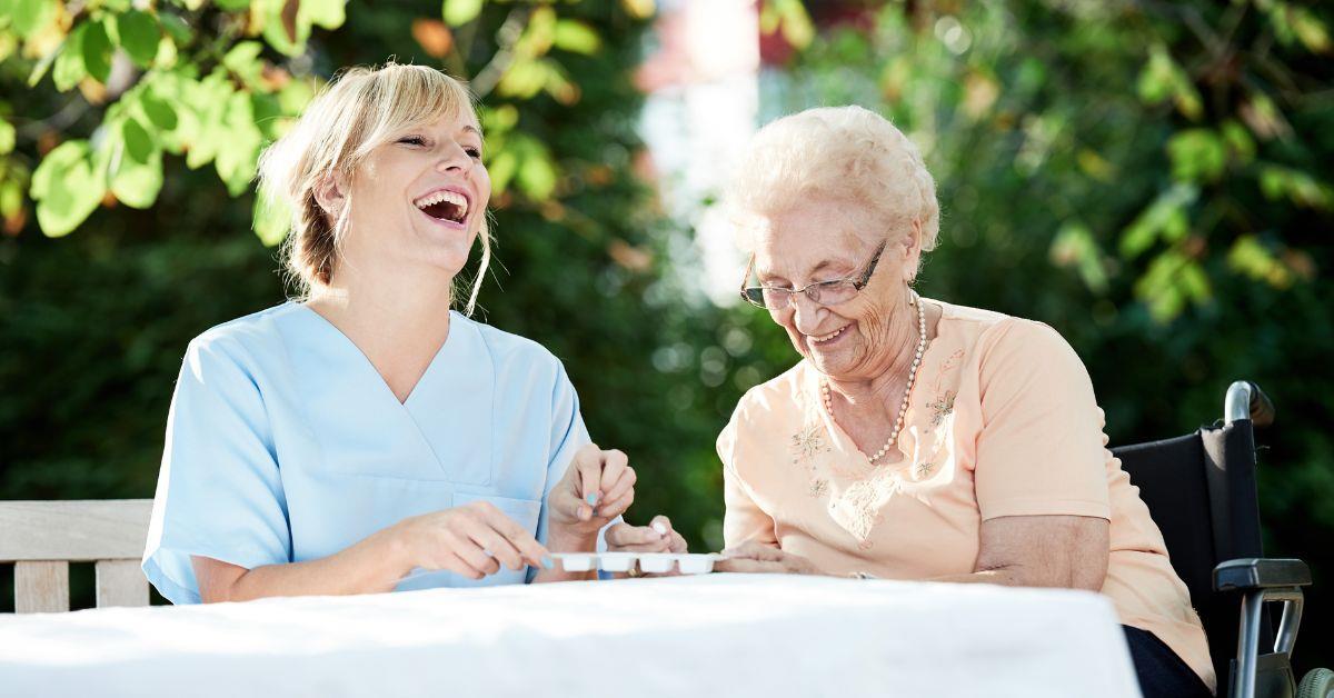 Betreuungsassistentin mit Seniorin im Garten