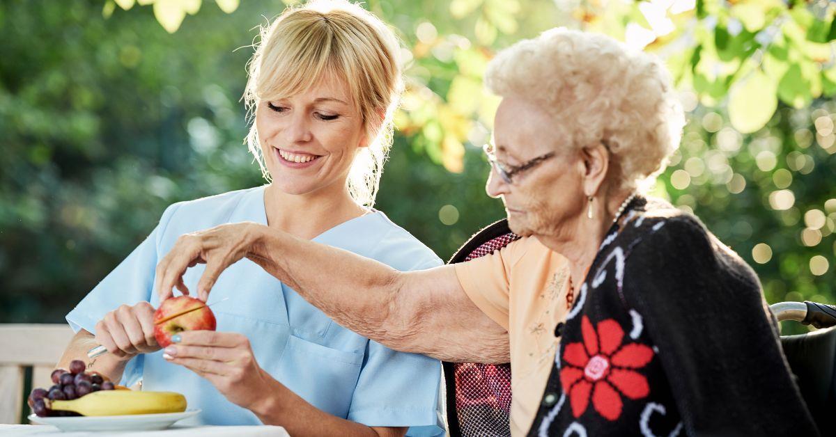 Seniorin und Betreuerin sitzen im Garten
