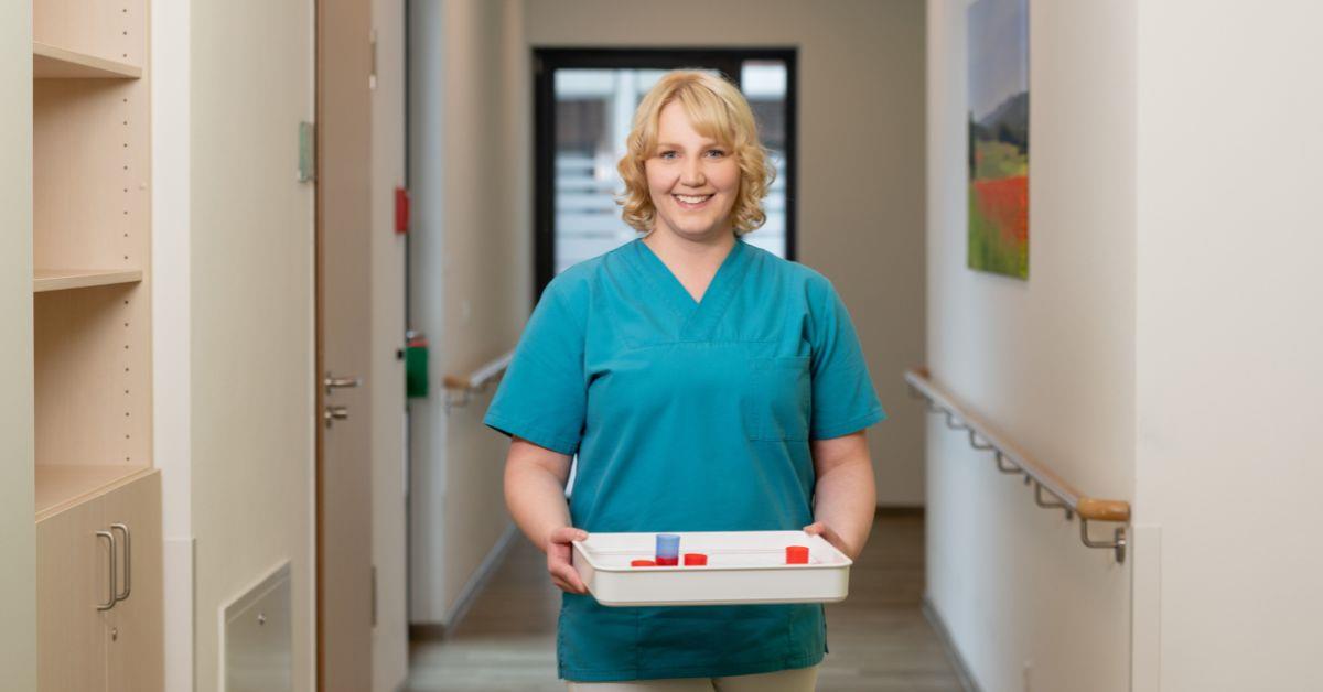 Examinierte Pflegefachkraft mit Tablett