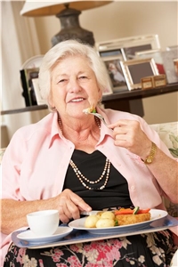 Seniorin mit geliefertem Mittagsmenü Seniorin mit geliefertem Mittagsmenü