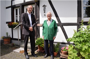 Caritas-Vorstand Dirk Hucko und Seniorin Angelika Siodmok vor ihrem Zuhause in Schmidt.