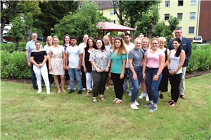 Azubigruppe mit Ausbildern. 20 Personen im Park.