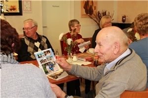 Schnappschüsse erfreuten die Teilnehmer. Senior zeigt Foto. Schnappschüsse erfreuten die Teilnehmer.