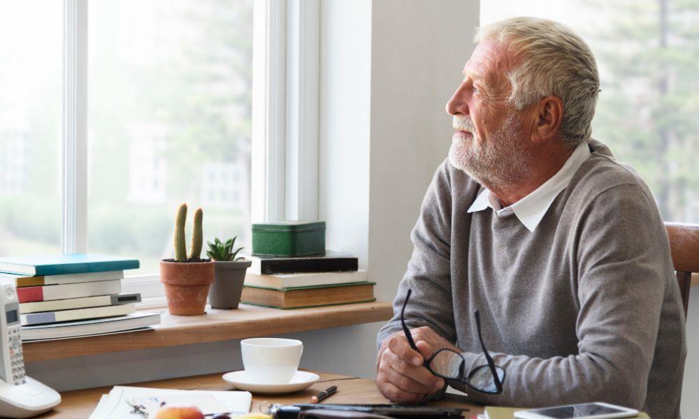 Senior schaut entspannt aus dem Fenster
