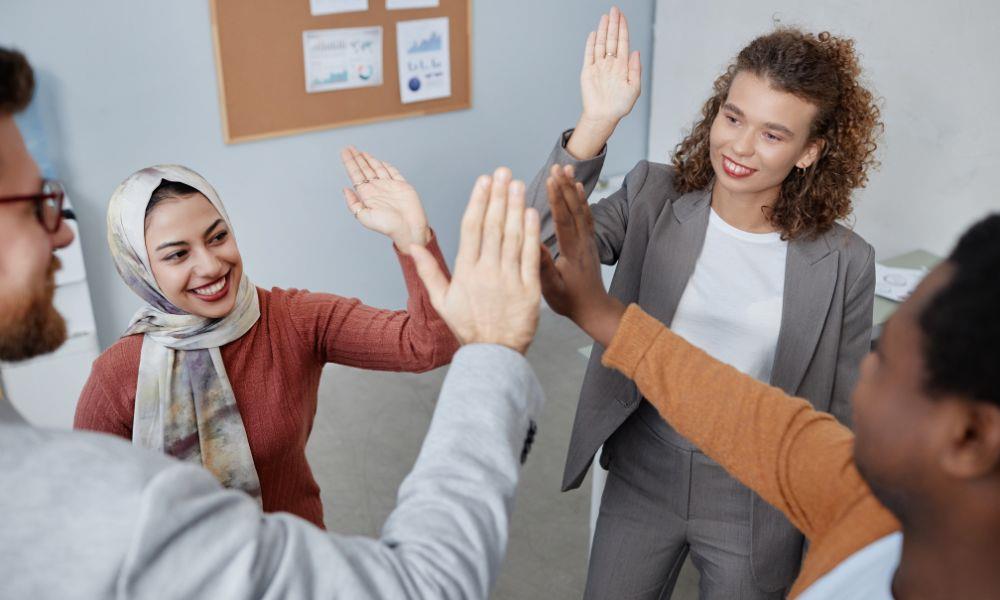 Junge Mitarbeitende geben sich High Five