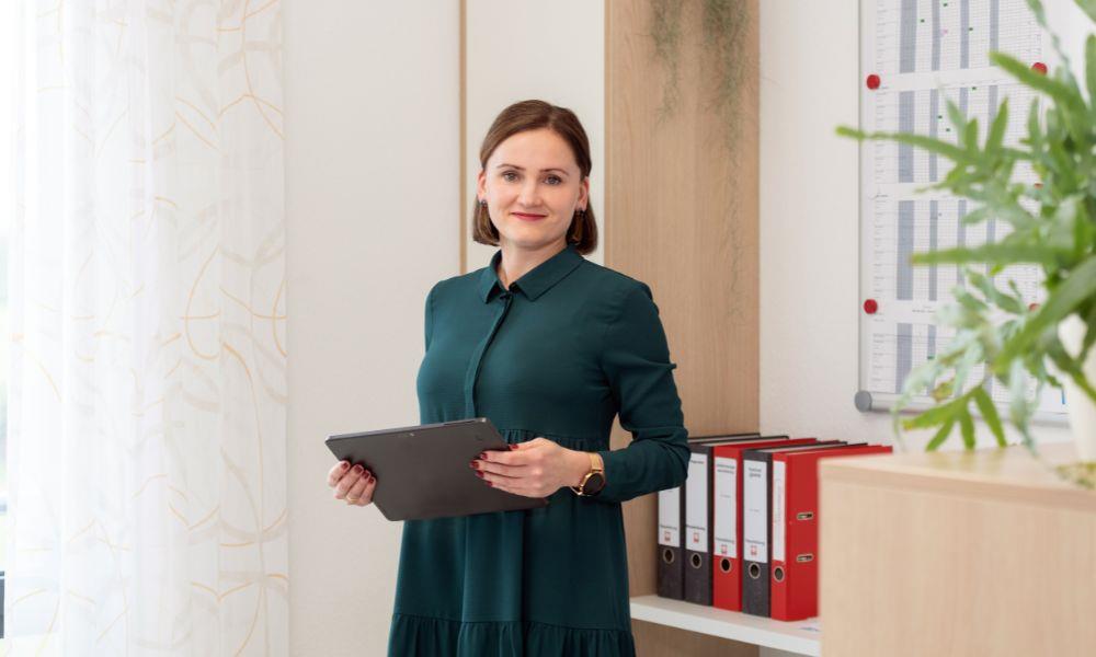 Mitarbeiterin steht mit Tablet im Büro