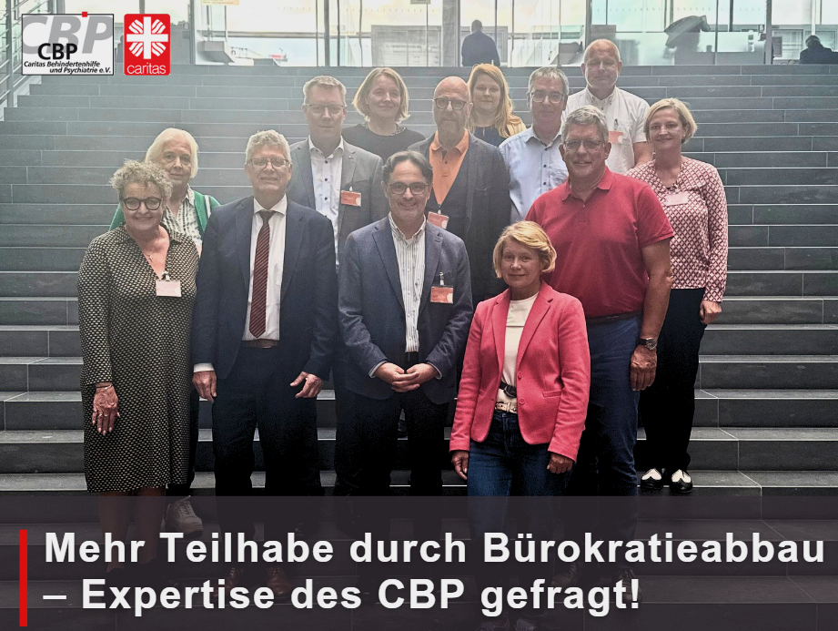 Gruppenfoto von zwölf Personen, die gestaffelt auf einer Treppe stehen.